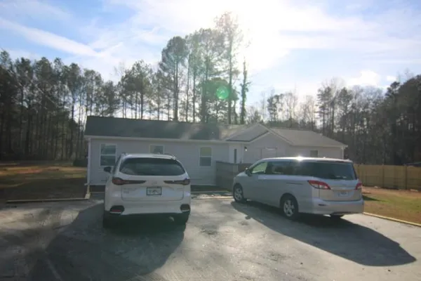 a view of a car parked in back yard of a house