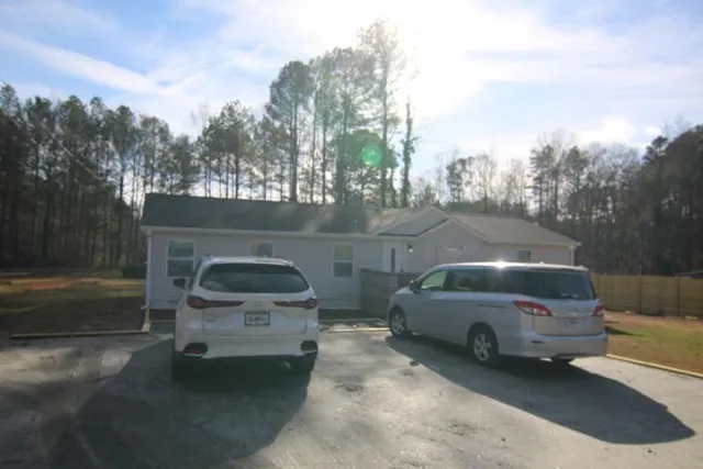 a view of a car parked in back yard of a house