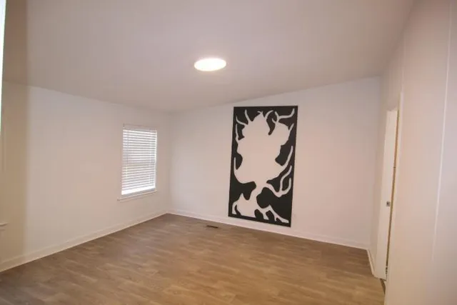 an empty room with window and wall painting