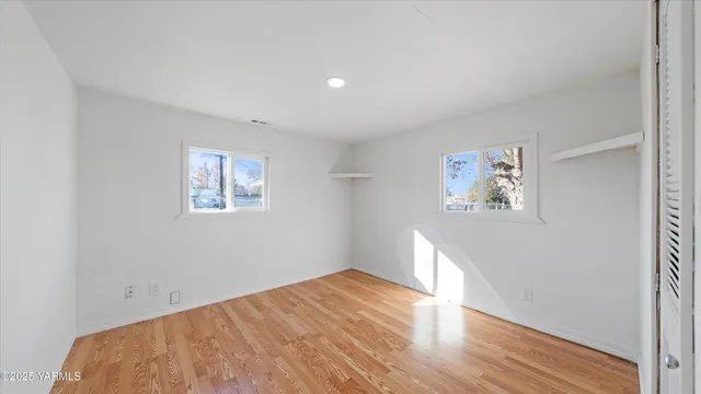 a view of empty room with wooden floor
