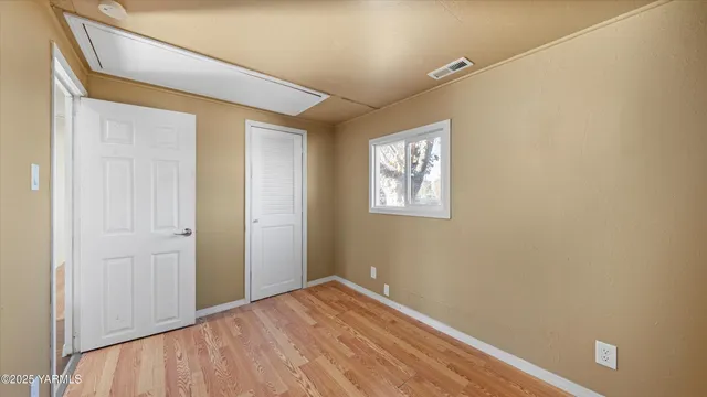 a view of empty room with wooden floor