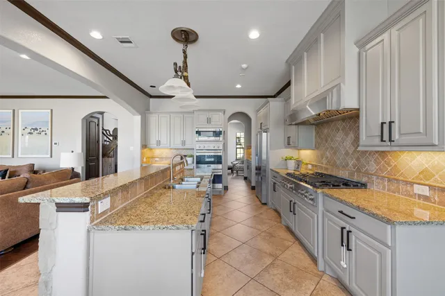 a kitchen with stainless steel appliances granite countertop a lot of counter space and a refrigerator