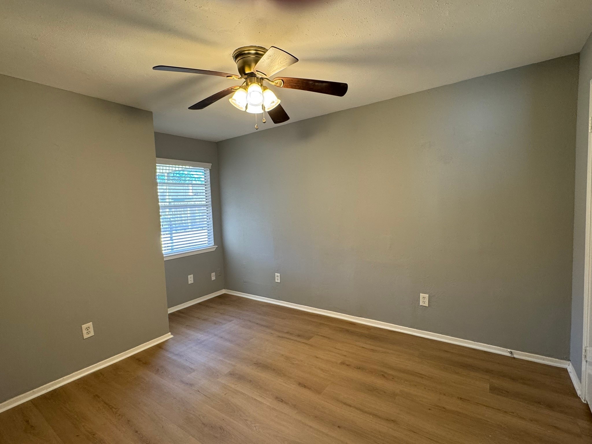 7231 Daylight Lane Houston, TX 77095 - Photo 11 of 11 an empty room with wooden floor chandelier fan and windows