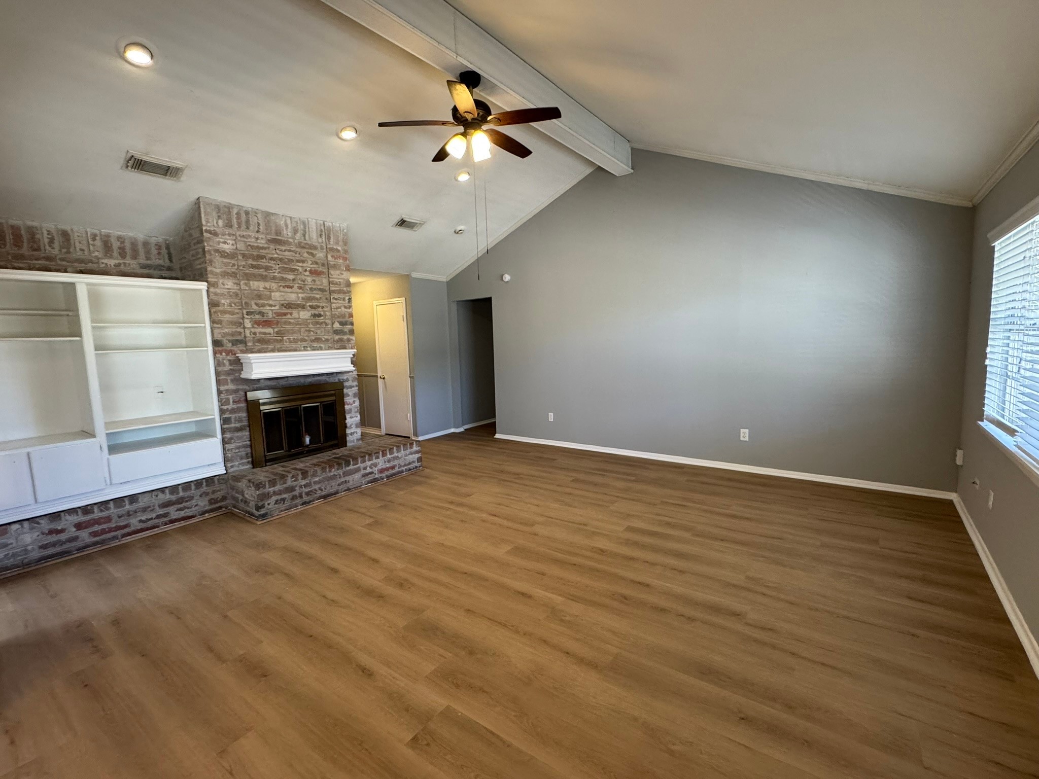 7231 Daylight Lane Houston, TX 77095 - Photo 4 of 11 an empty room with fireplace cabinet and windows