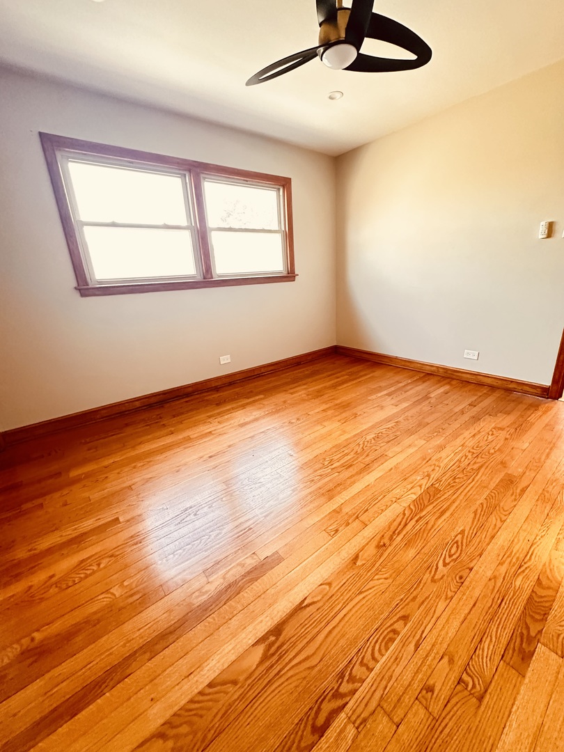 2823 West 71st Street Chicago, IL 60629 - Photo 12 of 18 a view of an empty room with window and wooden floor