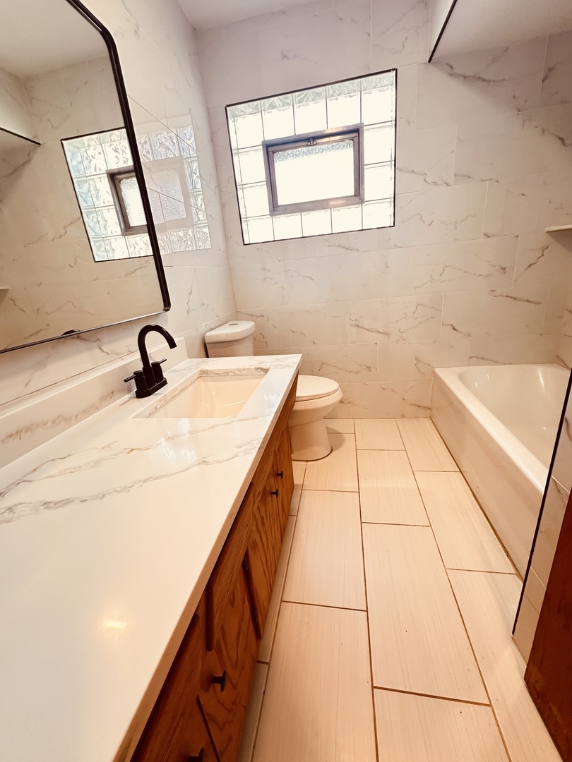 2823 West 71st Street Chicago, IL 60629 - Photo 14 of 18 a bathroom with a sink a toilet and mirror