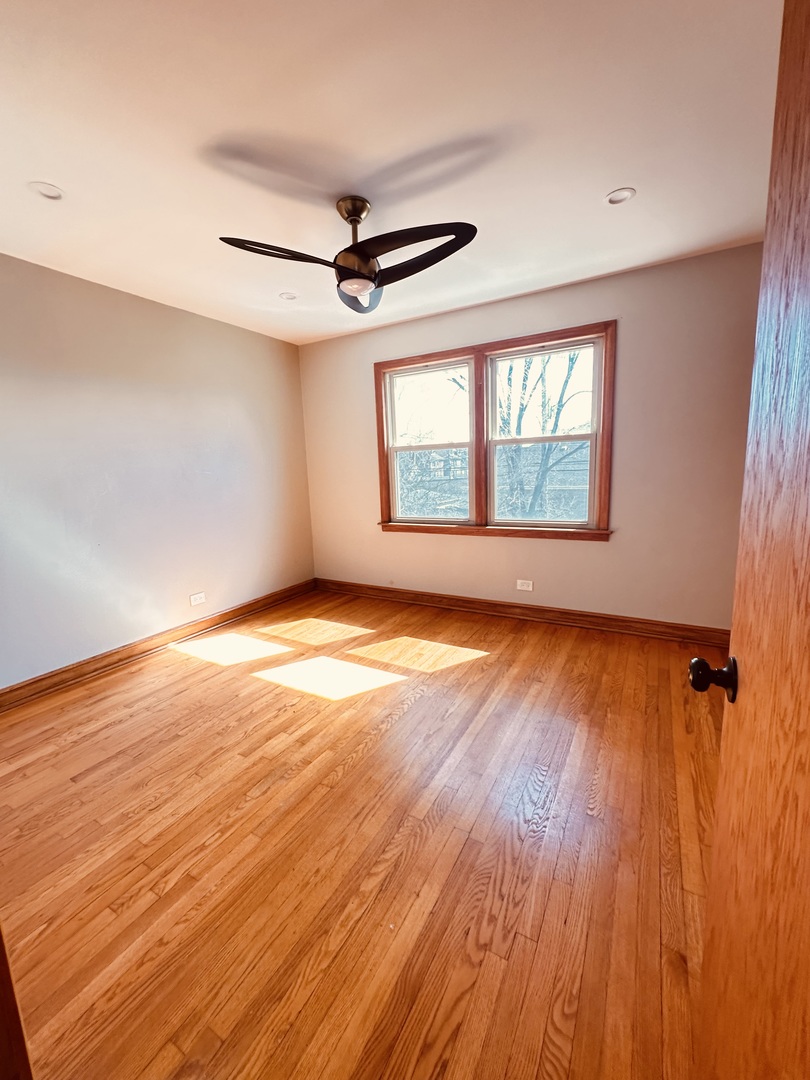 2823 West 71st Street Chicago, IL 60629 - Photo 16 of 18 an empty room with wooden floor fan and windows
