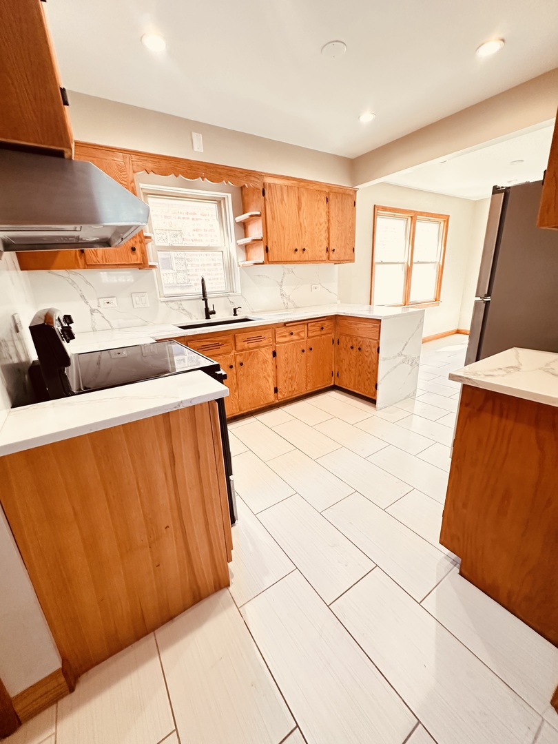 2823 West 71st Street Chicago, IL 60629 - Photo 7 of 18 a bedroom with stainless steel appliances kitchen island granite countertop sink and cabinets