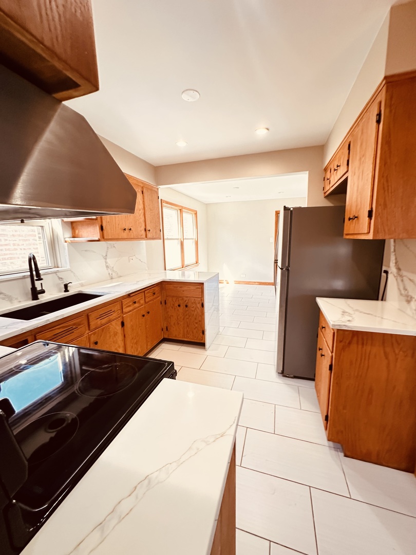 2823 West 71st Street Chicago, IL 60629 - Photo 8 of 18 a kitchen with stainless steel appliances kitchen island sink stove and cabinets