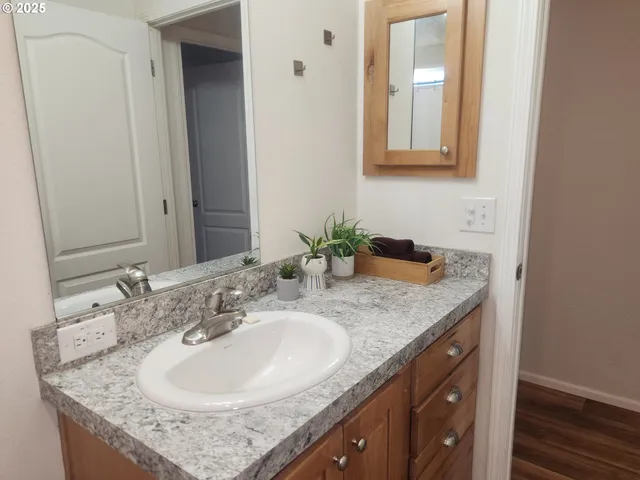 a bathroom with a granite countertop sink and a mirror