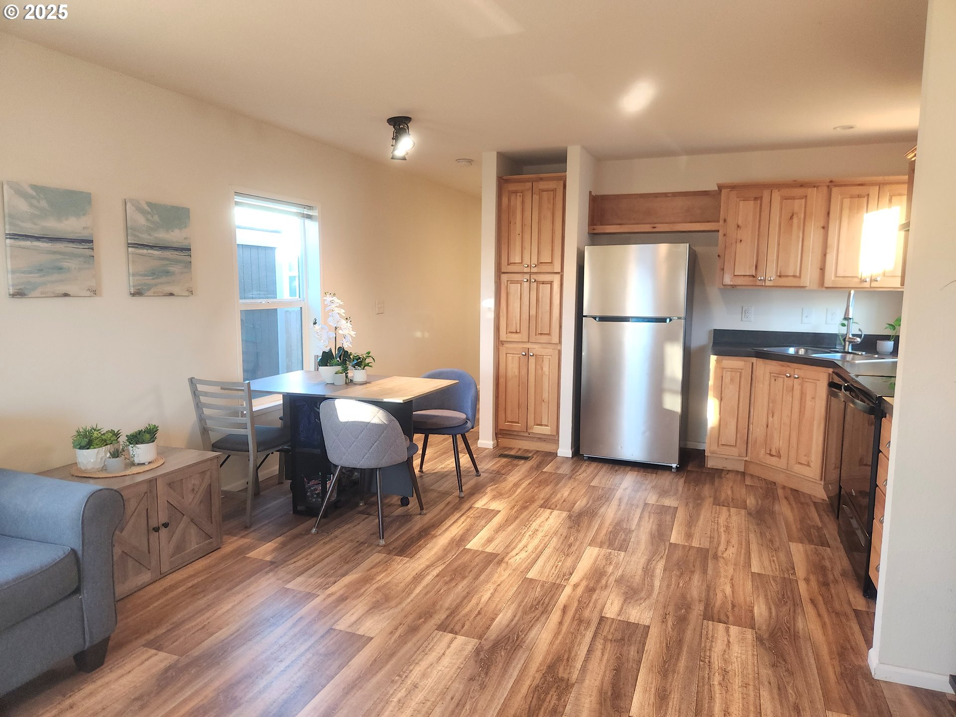 515 Southeast Sheridan Road, Unit 6 Sheridan, OR 97378 - Photo 6 of 30 a kitchen with a table chairs refrigerator and a window