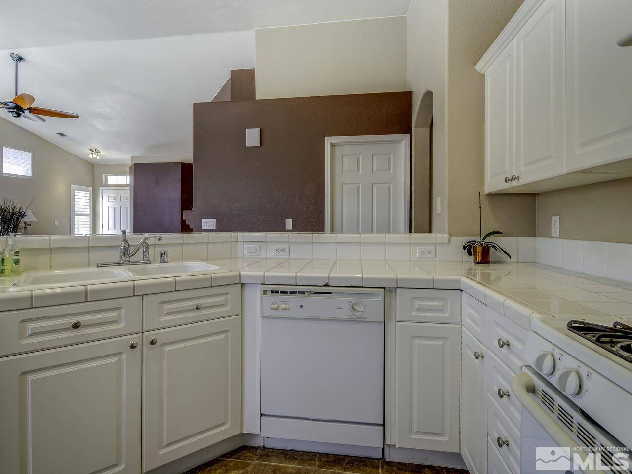 1789 River Gorge Drive Reno, NV 89521 - Photo 8 of 24 a kitchen with white cabinets and sink