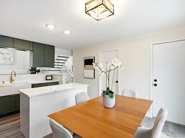 a kitchen with stainless steel appliances granite countertop a sink a stove a dining table and chairs