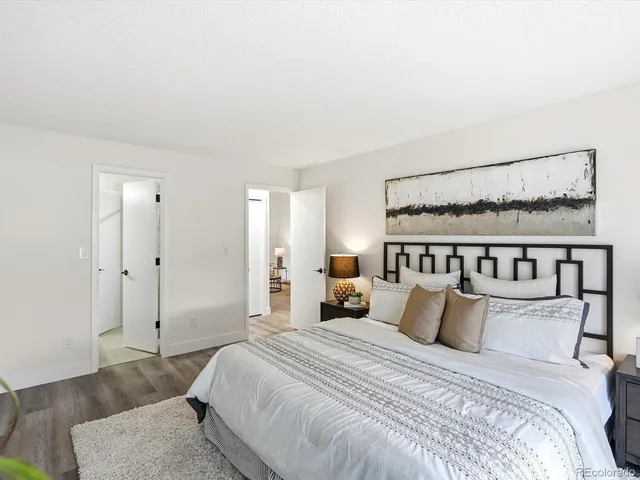 a bed room with a bed and a painting on the wall