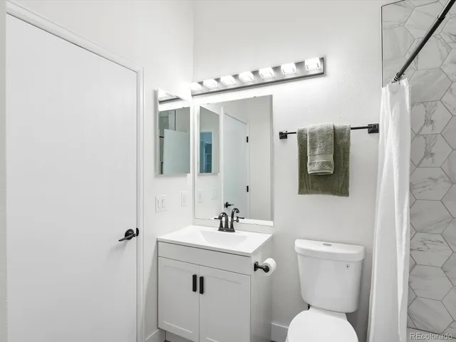 a bathroom with a toilet a sink and mirror