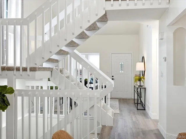a view of staircase with lots of frames on wall and wooden floor
