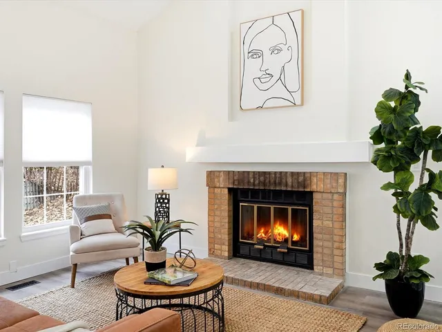 a living room with furniture a potted plant and a fireplace