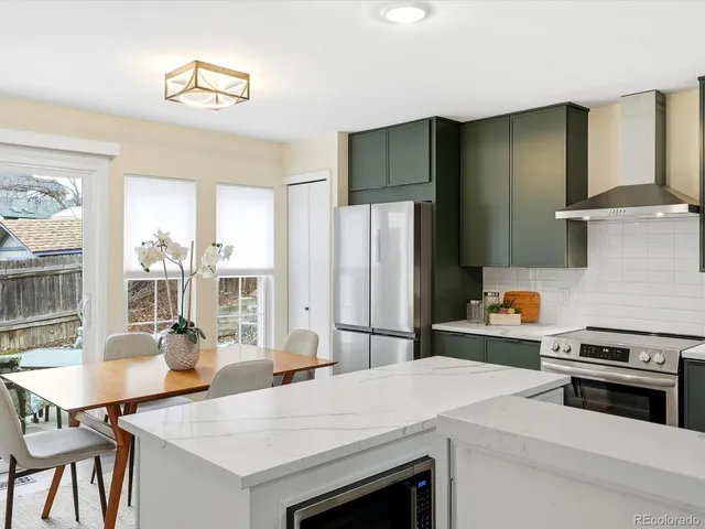 a kitchen with a stove a refrigerator and a dining table