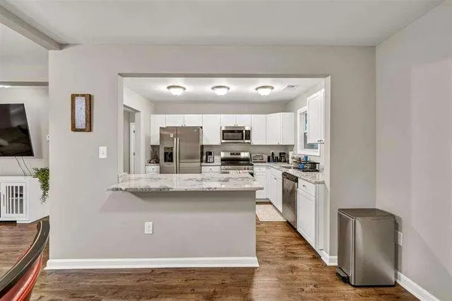 a view of kitchen with stainless steel appliances granite countertop refrigerator sink and stove