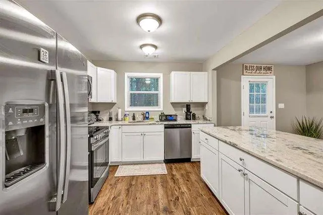 a kitchen with granite countertop appliances cabinets and a sink