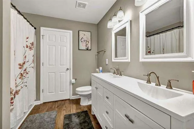 a bathroom with a sink toilet a mirror and shower