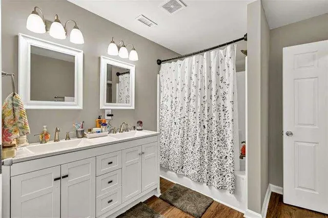 a bathroom with a double vanity sink mirror and shower