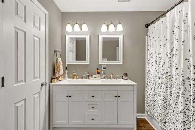 a bathroom with double sink and a mirror