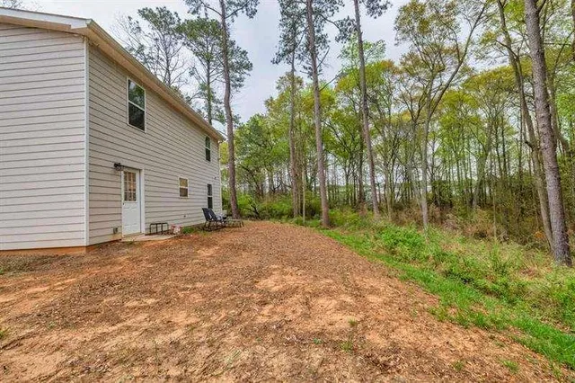 a view of a house with backyard and trees