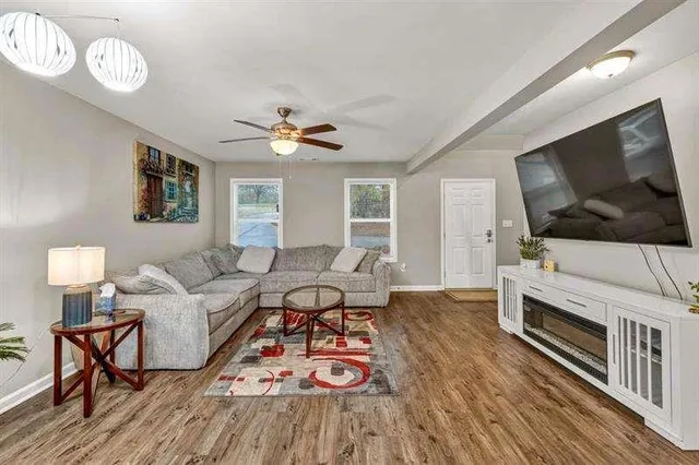 a living room with furniture a flat screen tv and a window