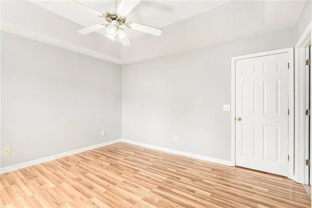 a view of a room with wooden floor and a ceiling fan