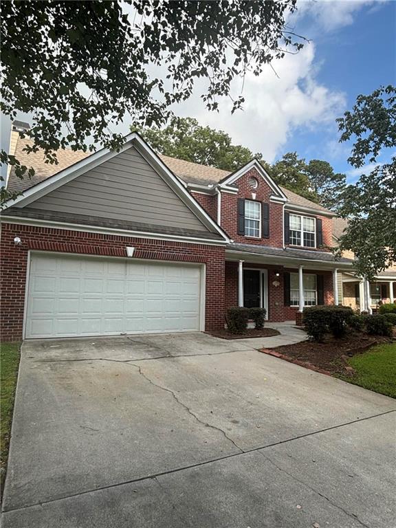 a front view of a house with a garden and trees