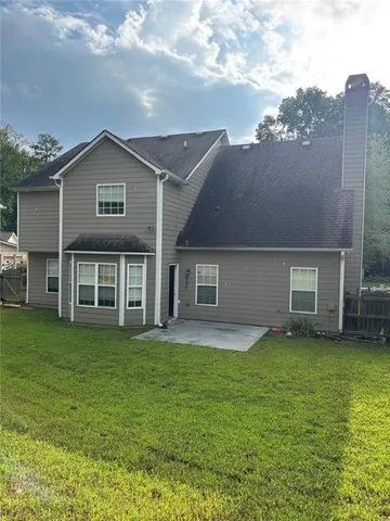 a backyard of a house with table and chairs
