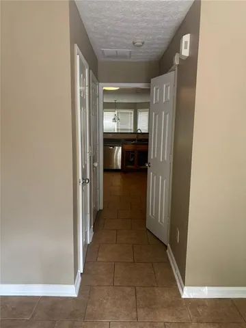 a view of a hallway to a livingroom and a kitchen