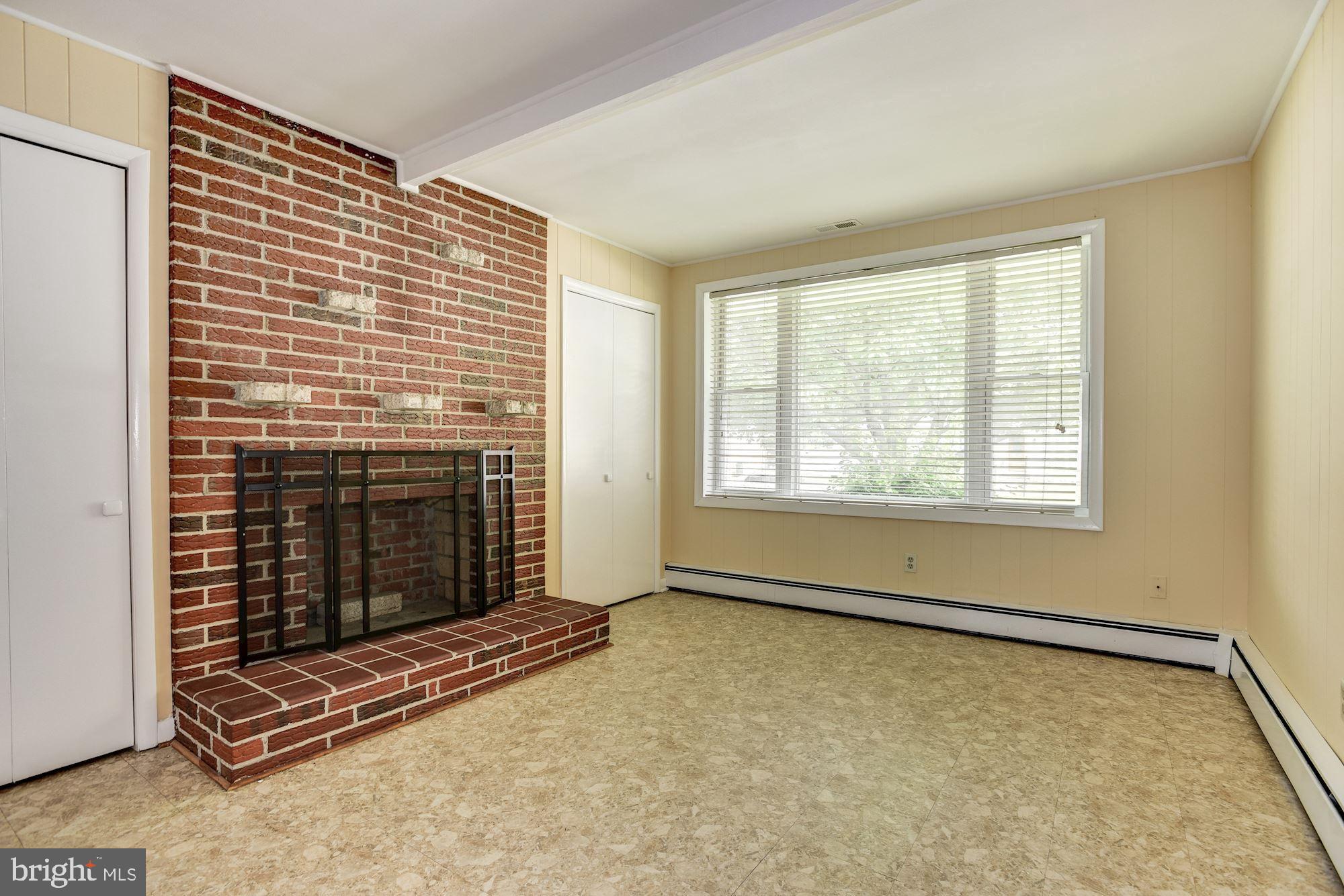 8492 Laurel Road Pasadena, MD 21122 - Photo 13 of 46 a view of an empty room with a fireplace and a window