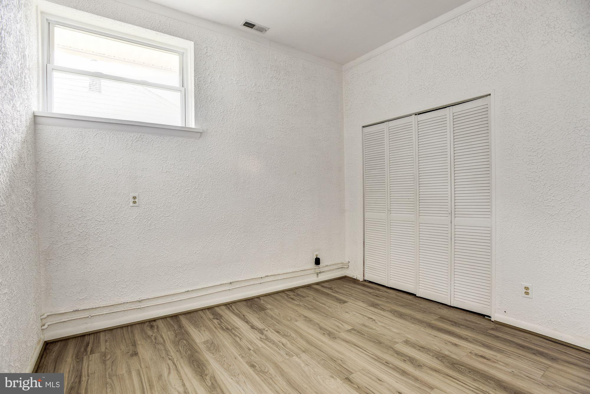 8492 Laurel Road Pasadena, MD 21122 - Photo 27 of 46 an empty room with wooden floor and windows
