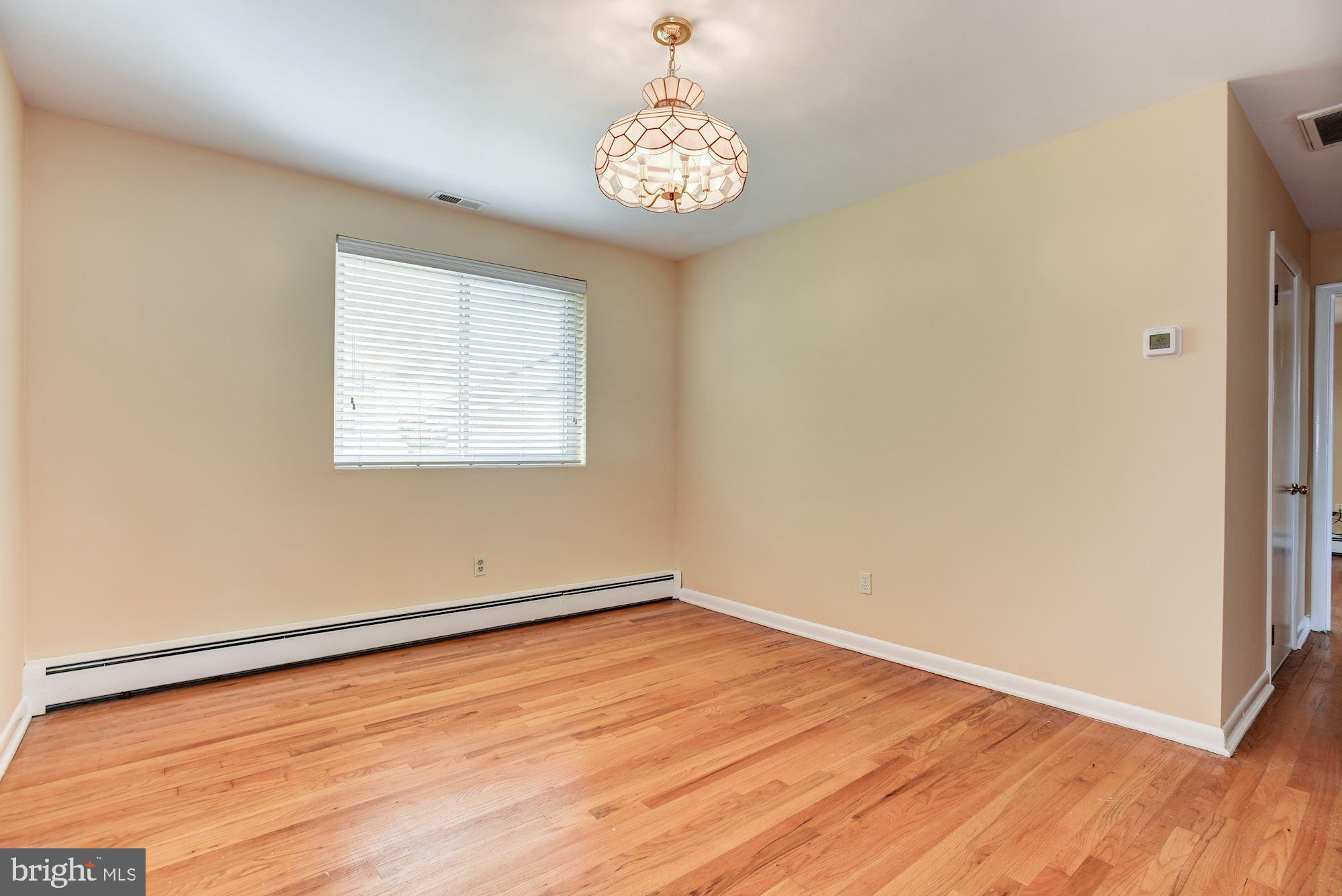 8492 Laurel Road Pasadena, MD 21122 - Photo 6 of 46 an empty room with wooden floor and windows