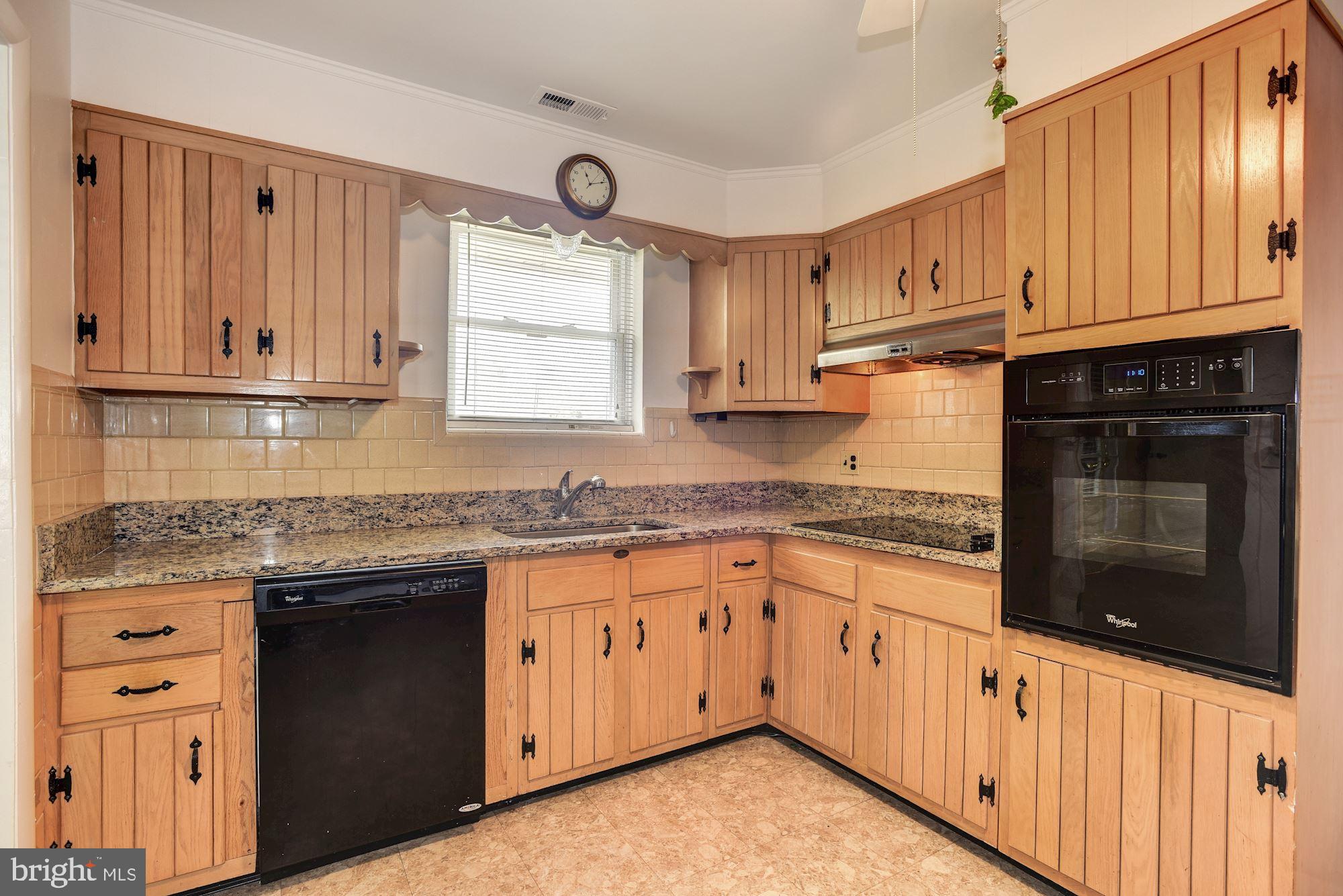 8492 Laurel Road Pasadena, MD 21122 - Photo 8 of 46 a kitchen with granite countertop stainless steel appliances white cabinets granite counter tops and a wooden floors