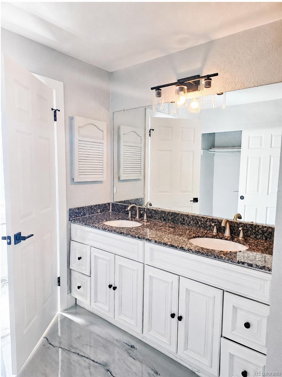4716 Freeport Way Denver, CO 80239 - Photo 12 of 29 a bathroom with a granite countertop sink and a mirror