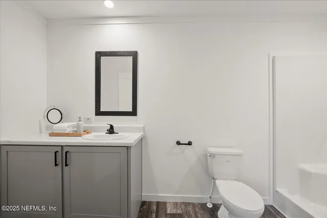 a bathroom with a toilet a sink and mirror
