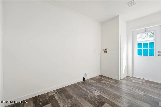 a view of empty room with wooden floor