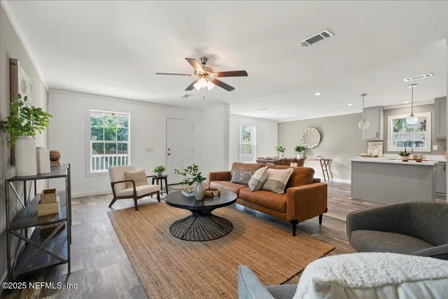 a living room with furniture kitchen view and a window