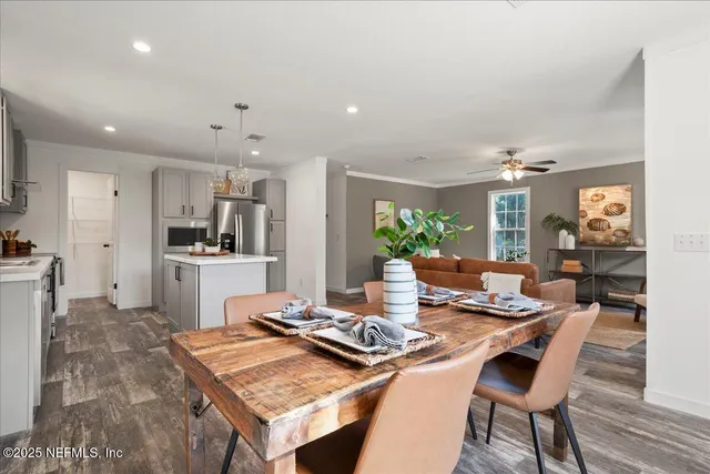 a kitchen with a dining table chairs and refrigerator