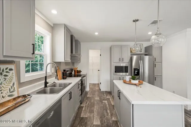 a kitchen with stainless steel appliances kitchen island a sink stove and refrigerator