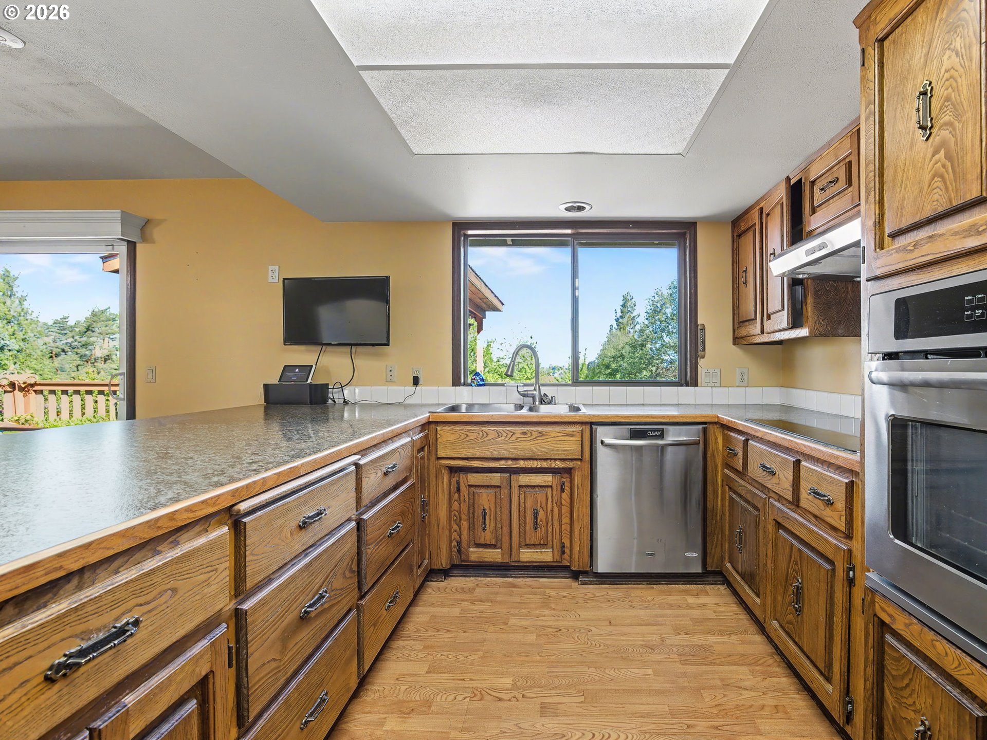 407 Southwest 7th Street Gresham, OR 97080 - Photo 14 of 48 a large kitchen with stainless steel appliances granite countertop a sink and dishwasher a stove top oven with wooden floor