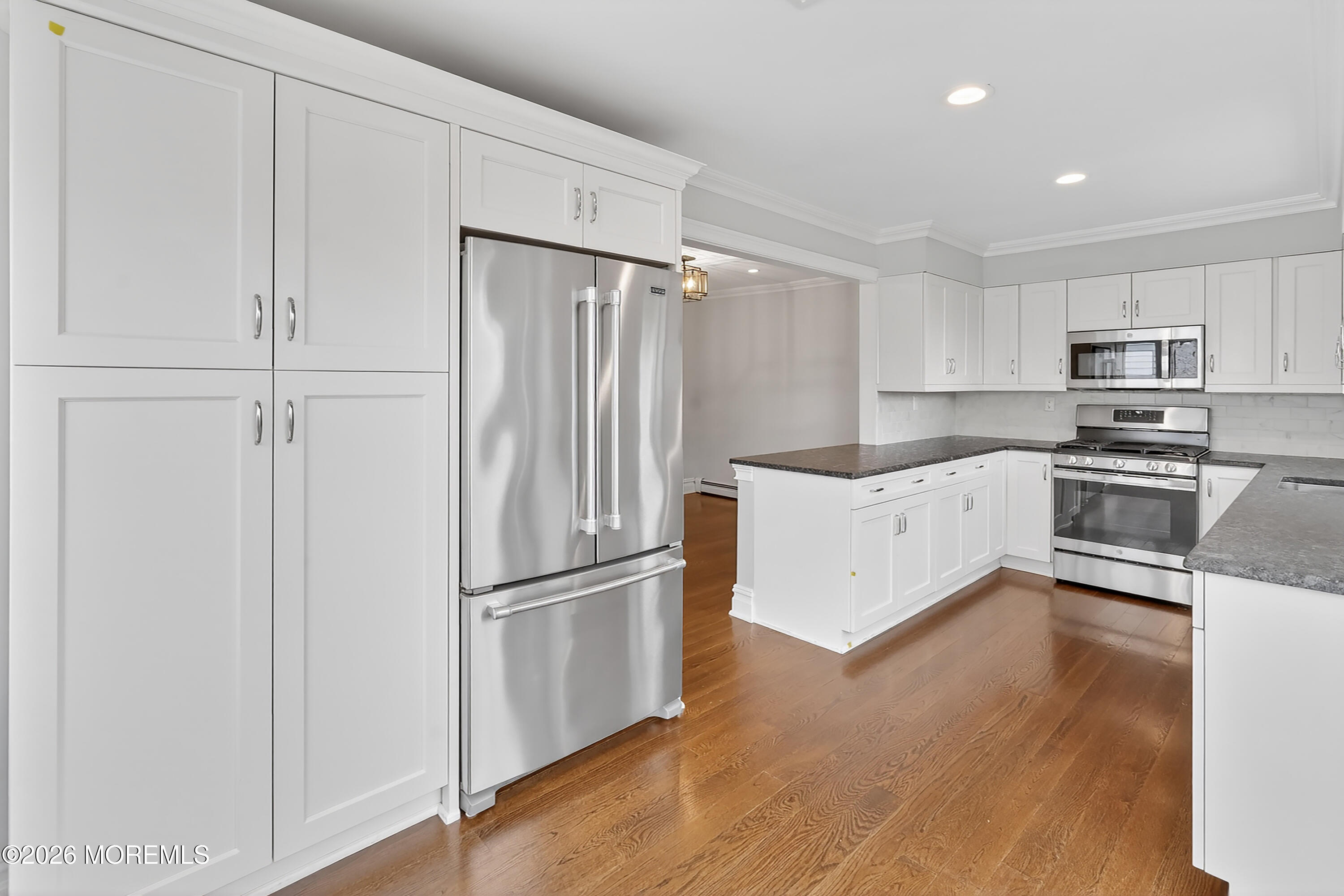 65 East River Road, Unit 20 Rumson, NJ 07760 - Photo 5 of 31 a kitchen with kitchen island white cabinets and stainless steel appliances