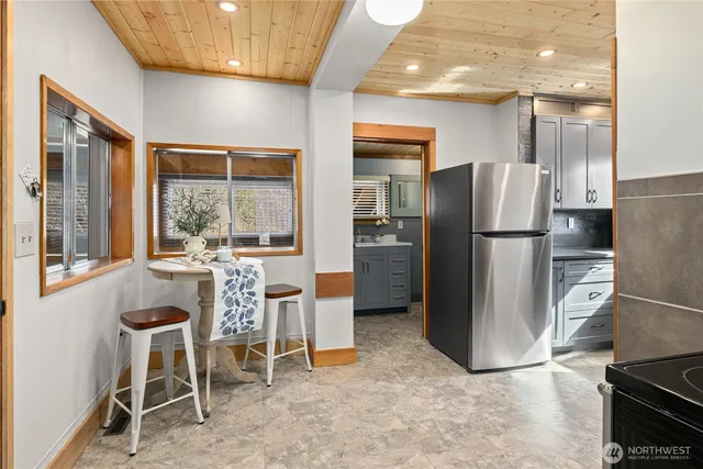 a kitchen with a refrigerator a table and chairs