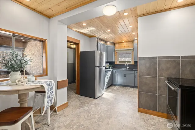 a kitchen with stainless steel appliances a refrigerator and a table