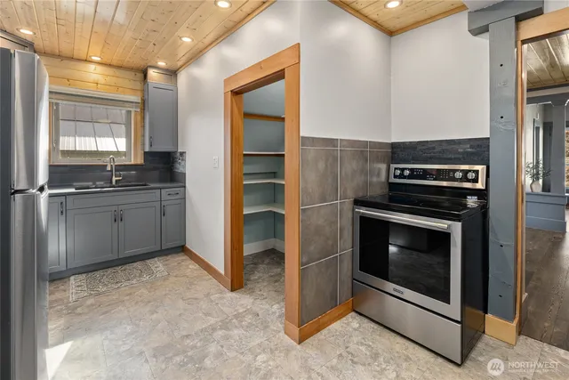 a kitchen with granite countertop a sink stove and refrigerator