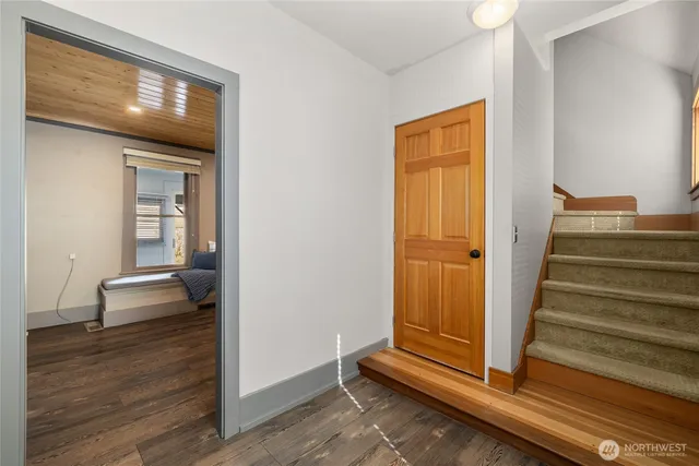 a view of a hallway with wooden floor and staircase