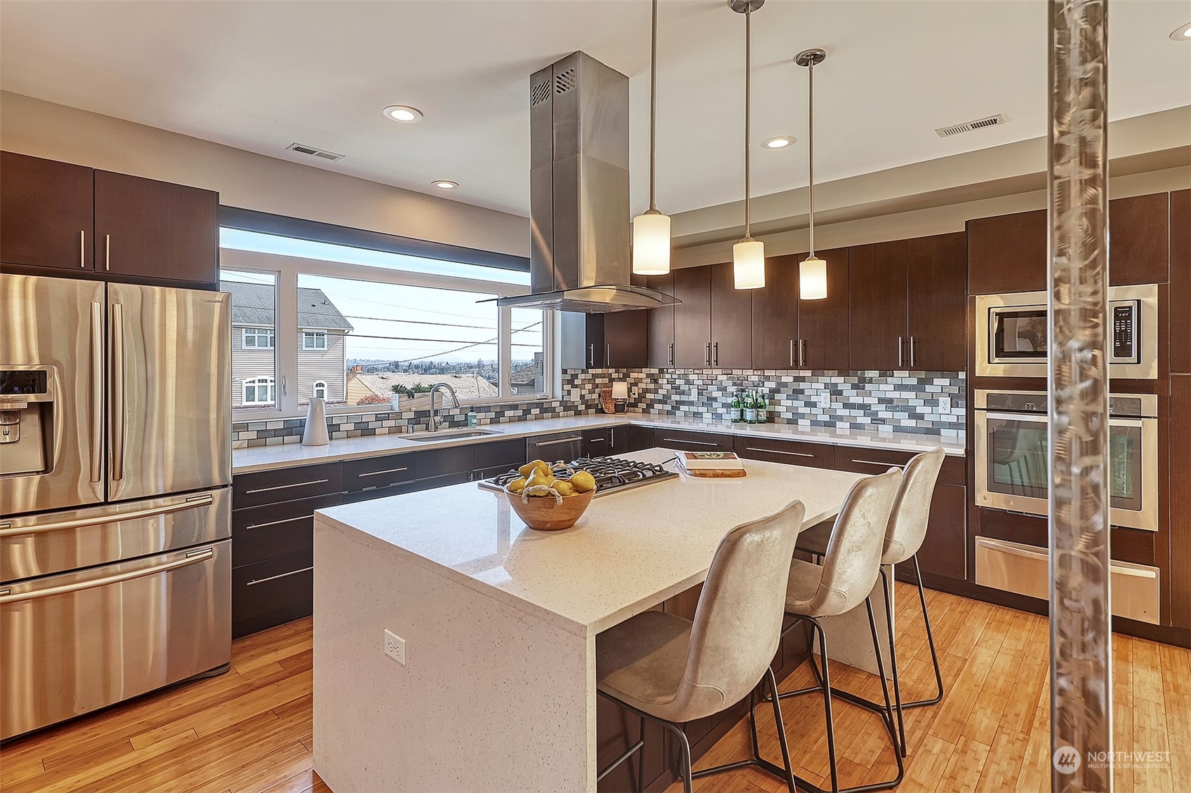 3263 35th Avenue Southwest Seattle, WA 98126 - Photo 5 of 38 a kitchen with stainless steel appliances kitchen island granite countertop a refrigerator a stove and a wooden floors